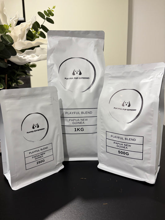Three coffee bags labeled 'Playful Blend' from Papua New Guinea on a dark surface with a light background.
